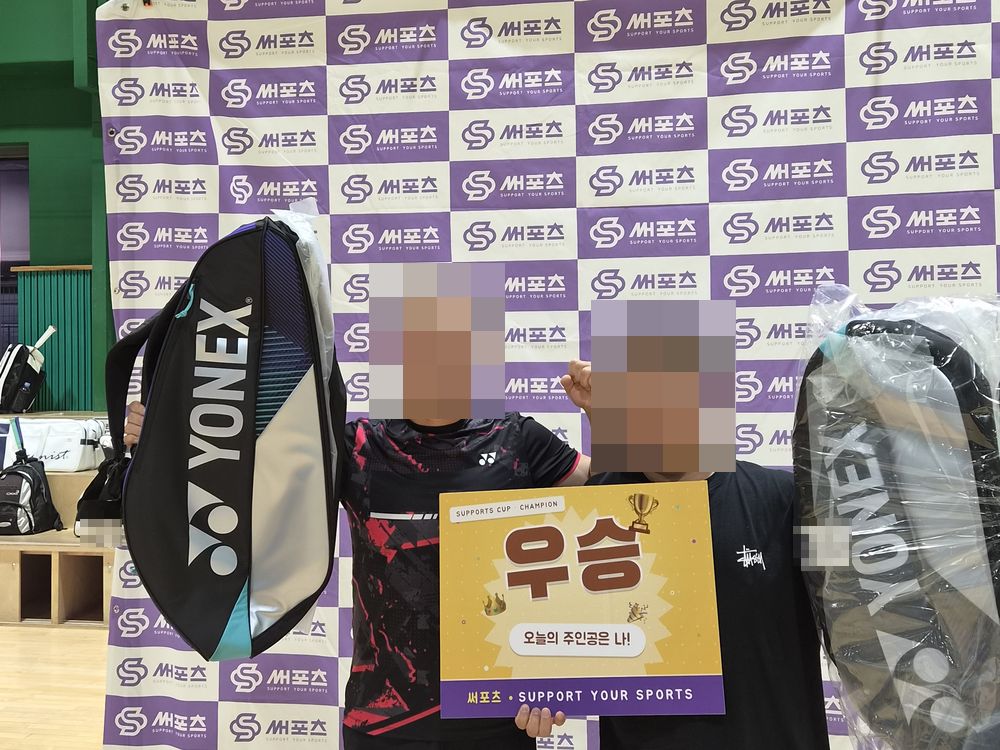 서울 버스 배드민턴 대회 우승 시상 — 써포츠 포토월 앞에서 우승 보드와 부상을 든 두 참가자(얼굴 모자이크)