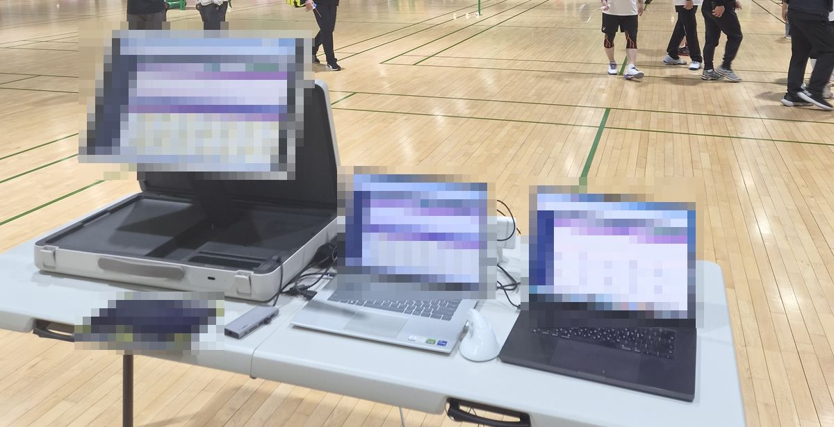 서울 버스 배드민턴 대회 본부 운영 데스크 — 모니터와 노트북에 띄운 써포츠 대진 관리 화면(화면 내용은 가림)